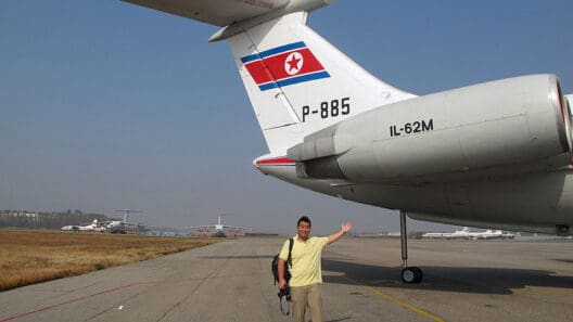 a man waving in front of an airplane
