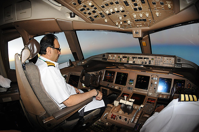 a man in a white uniform sitting in a cockpit of an airplane