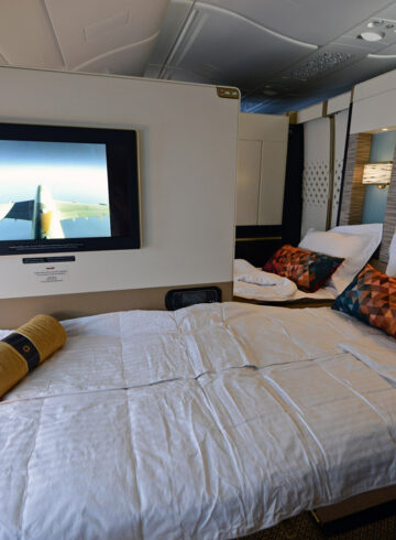 a bed with a tv on the wall