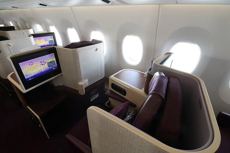 a seat and a monitor in the middle of an airplane