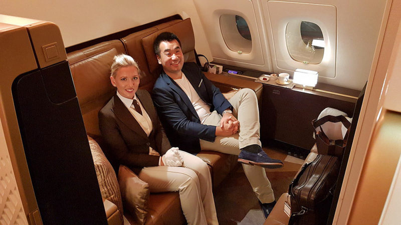 a man and woman sitting on a chair in a plane