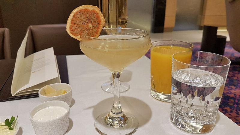 a glass of liquid with a slice of orange on top of it