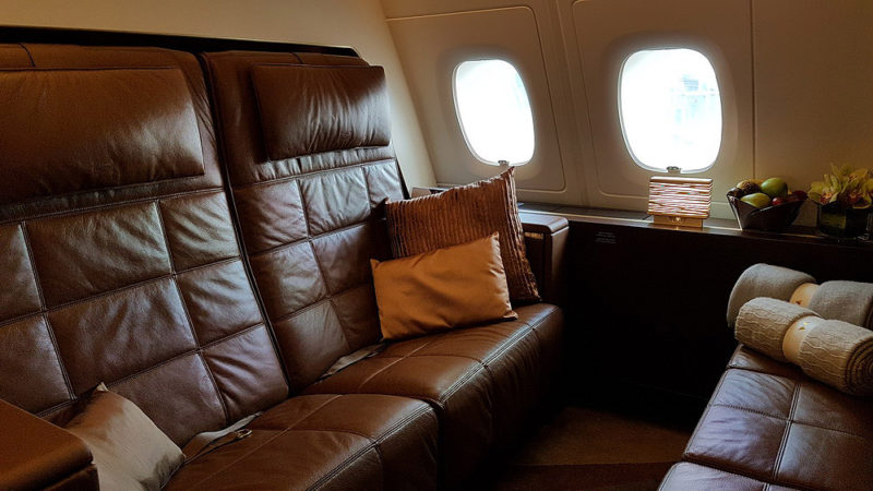 a leather couch with pillows on the side of the plane