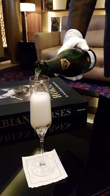 a person pouring a glass of champagne