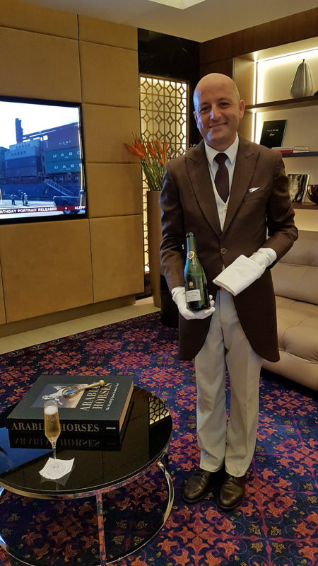 a man in a suit holding a bottle of champagne