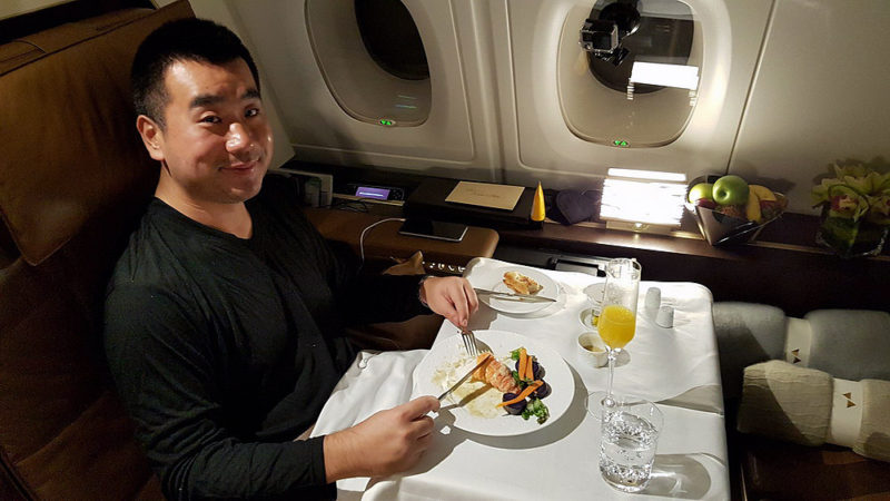 a man sitting at a table with food and drinks