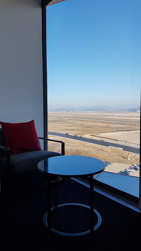a chair and table in a room with a view of the desert