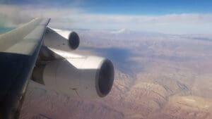 a plane wing with a mountain in the background