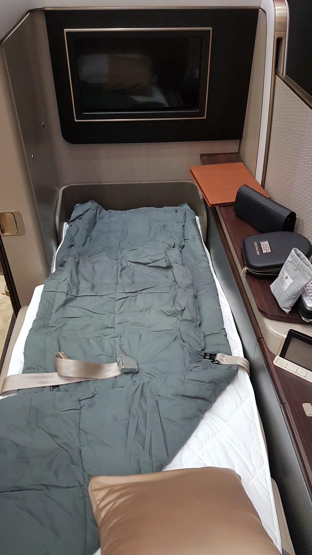 a bed with a seat belt and a bag on a table