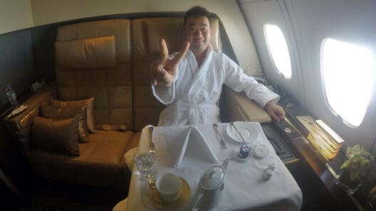 a man in a robe sitting at a table in a plane