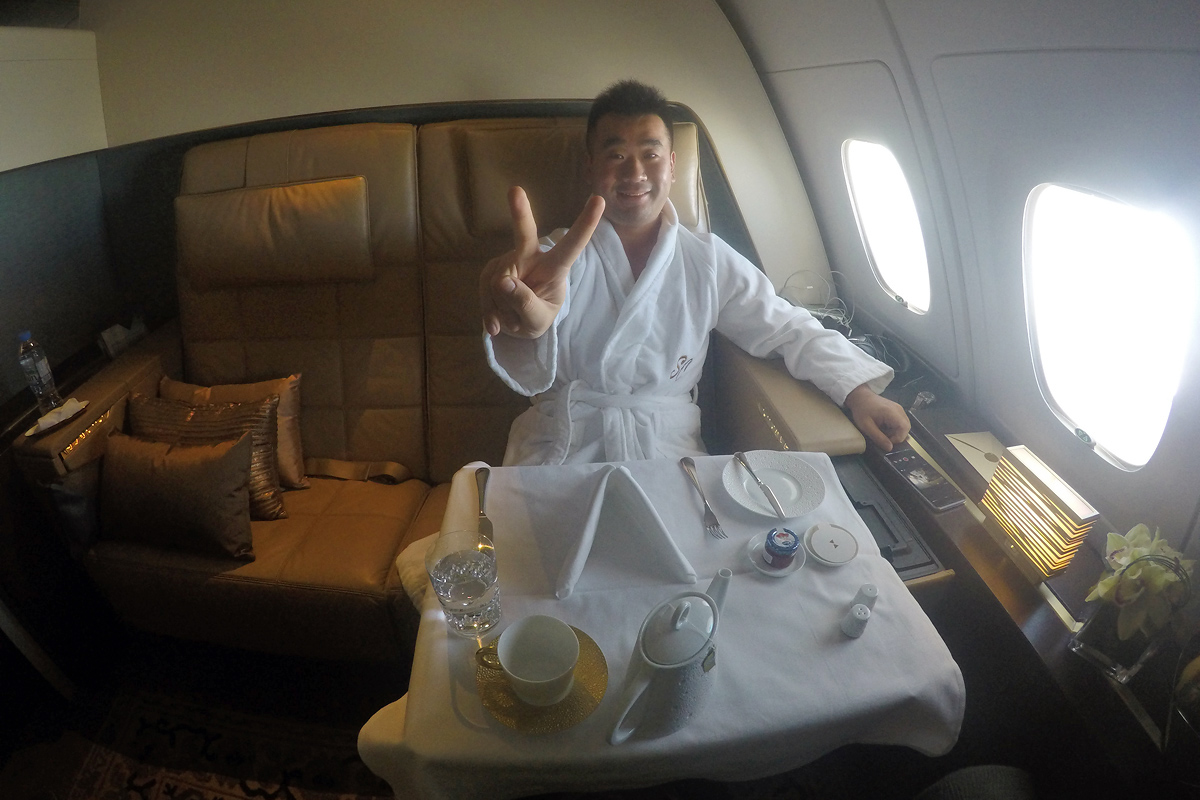 a man in a robe sitting at a table in a plane