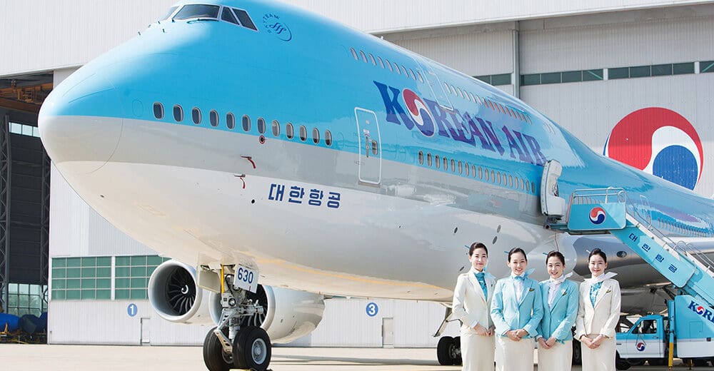 a group of women standing in front of a large airplane