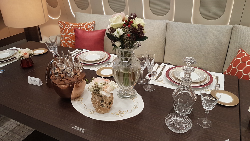 a table with a vase of flowers and plates