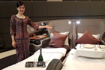 a woman standing in a room with beds and a tray of wine