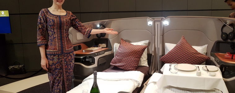 a woman standing in a room with beds and a tray of wine