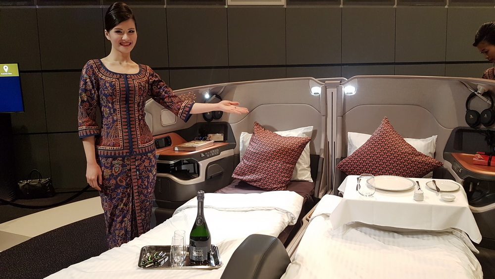 a woman standing in a room with beds and a tray of wine