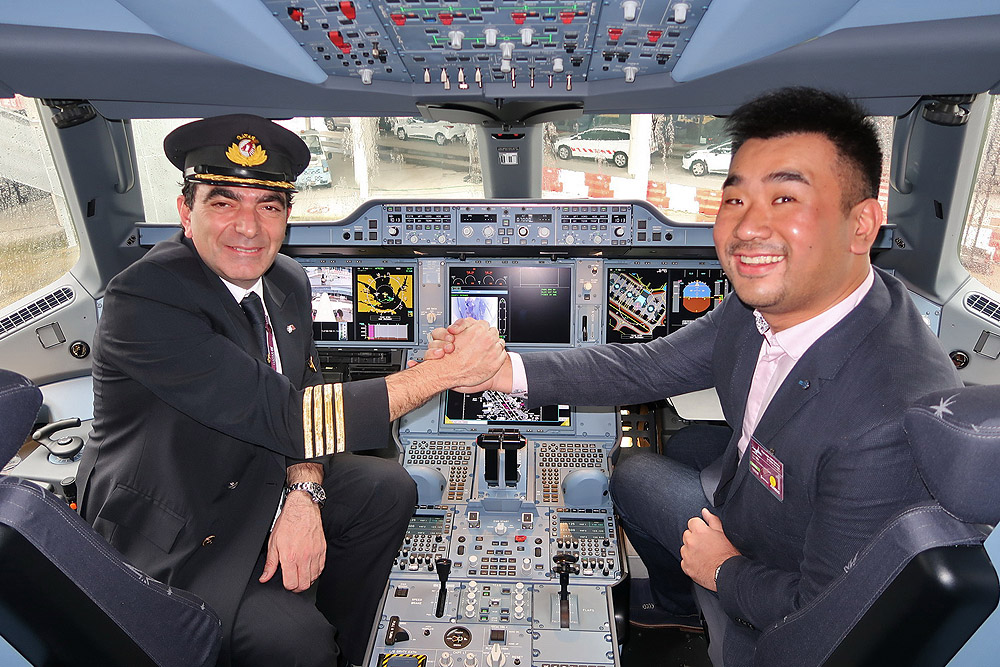 two men in a cockpit shaking hands