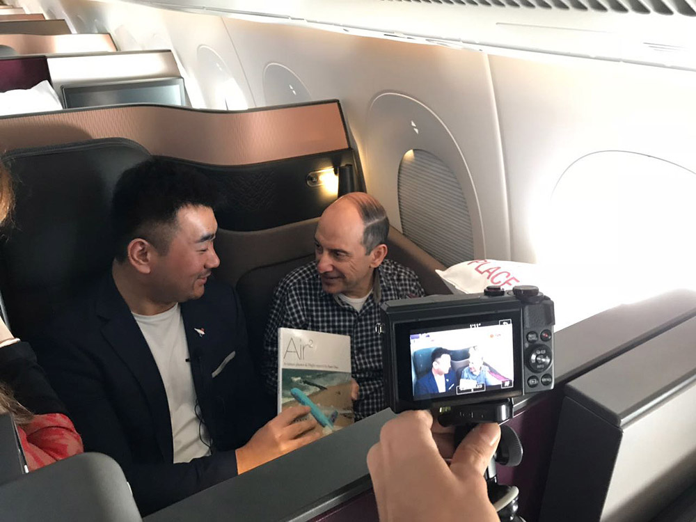 a man taking a picture of two men on an airplane