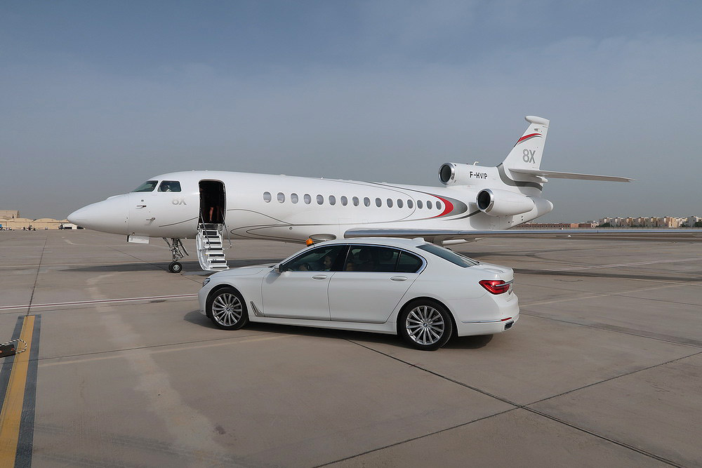 a white car and a plane on a runway
