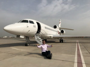 a man sitting on the ground next to an airplane