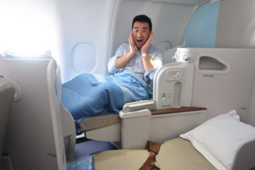 a man sitting in a plane with his hands on his face