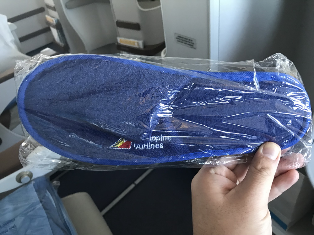 a hand holding a blue hat in a plastic bag
