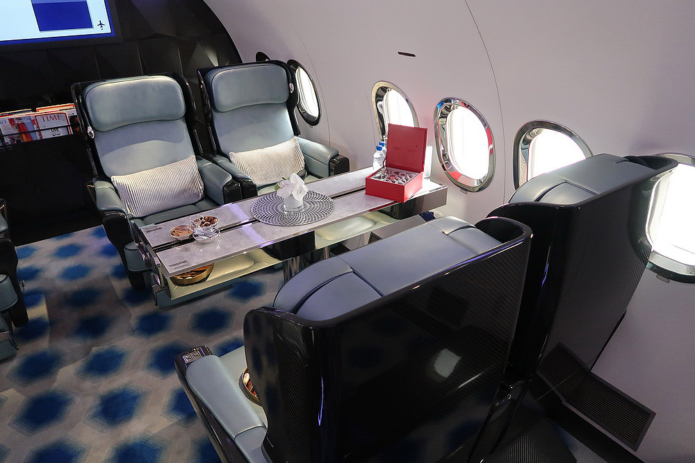 a table with food and a glass table in an airplane