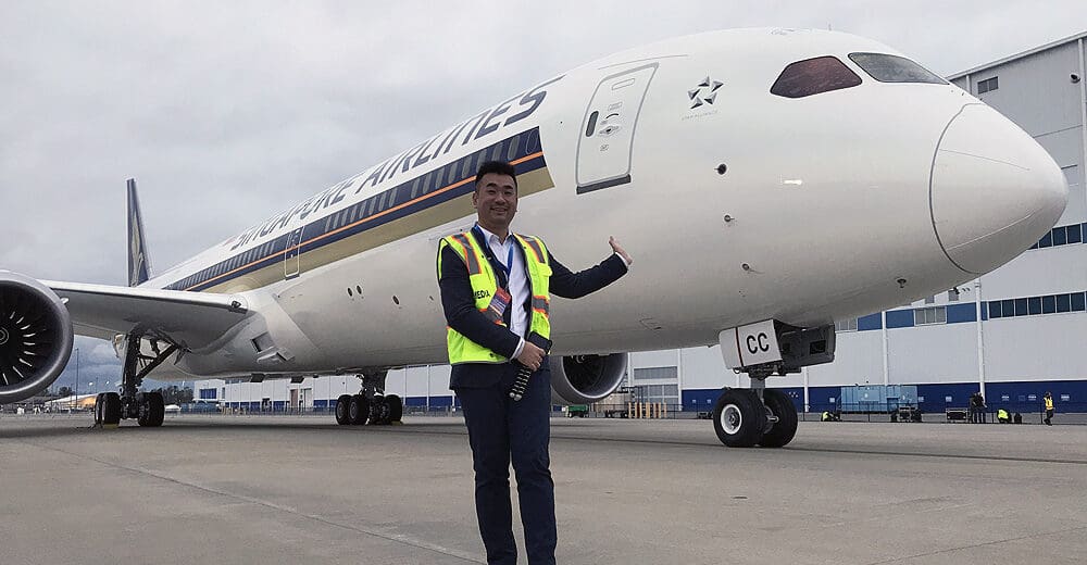a man in a vest standing in front of an airplane