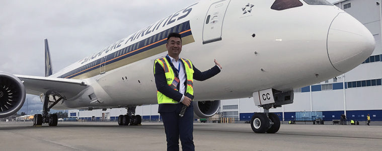 a man in a vest standing in front of an airplane