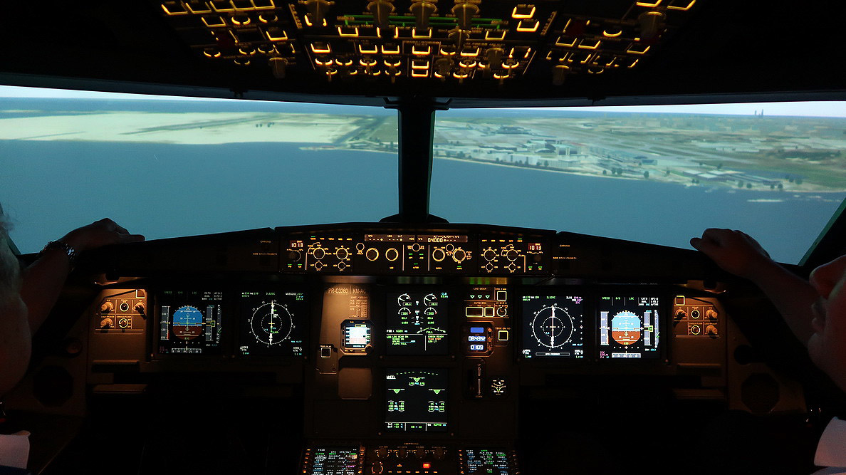 a cockpit of an airplane with a view of land and a plane