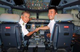 two men shaking hands in the cockpit of an airplane