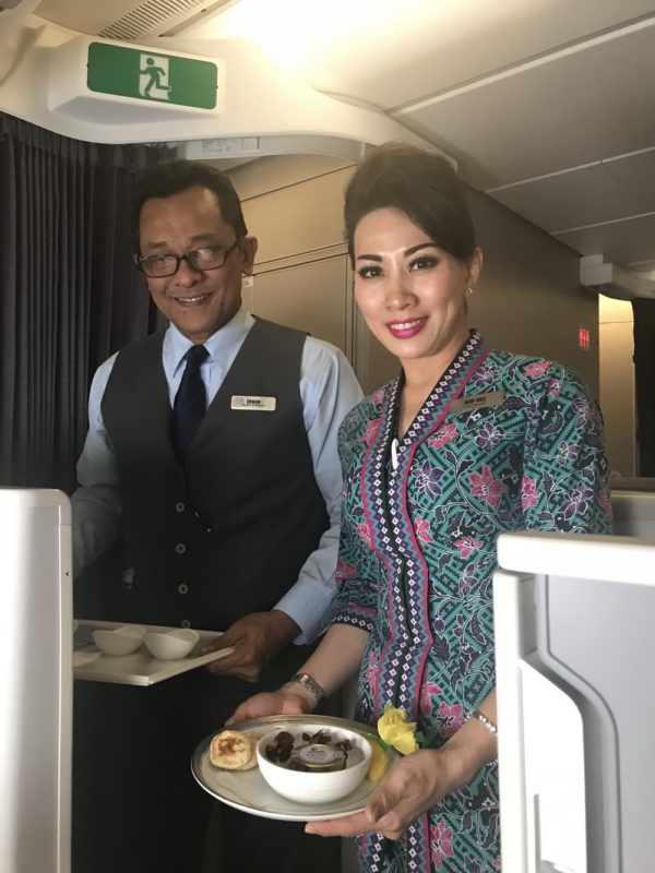 a man and woman holding food in a plane
