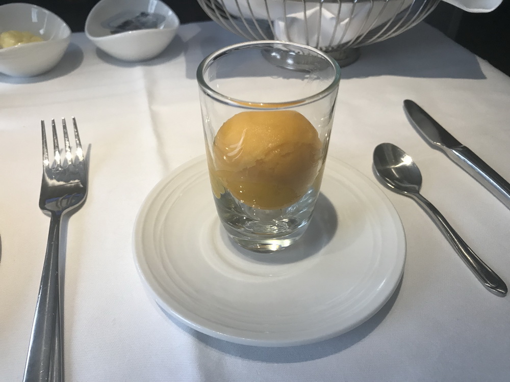 a glass with a ball of ice cream on a plate