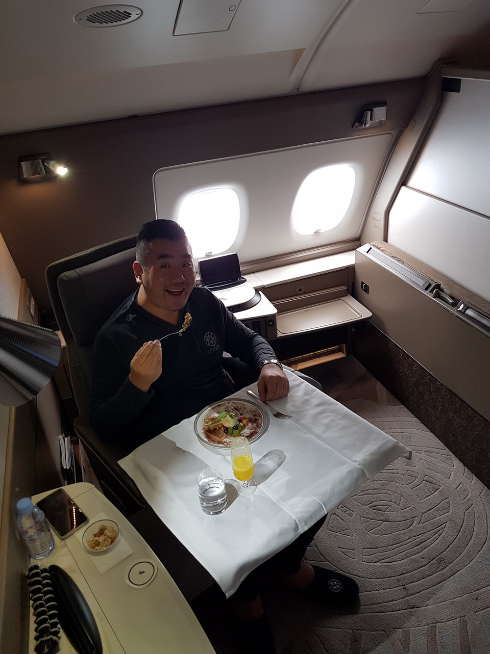 a man sitting in a chair eating food in a plane