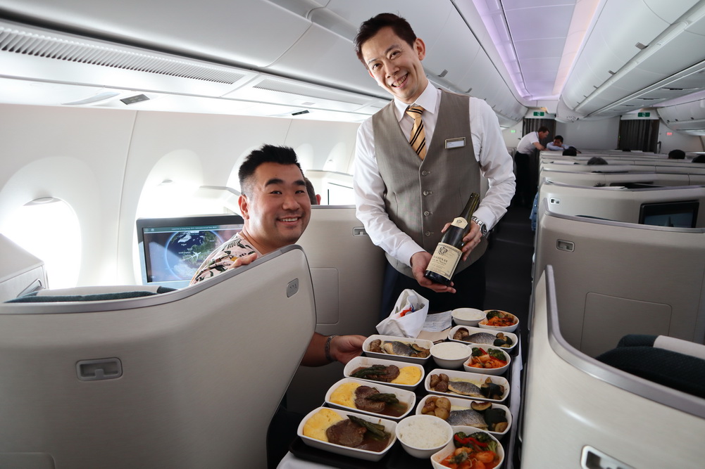 a man serving food on a plane