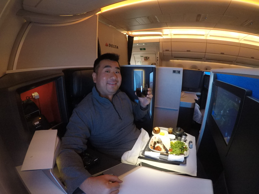 a man sitting in a chair with a glass of wine and food