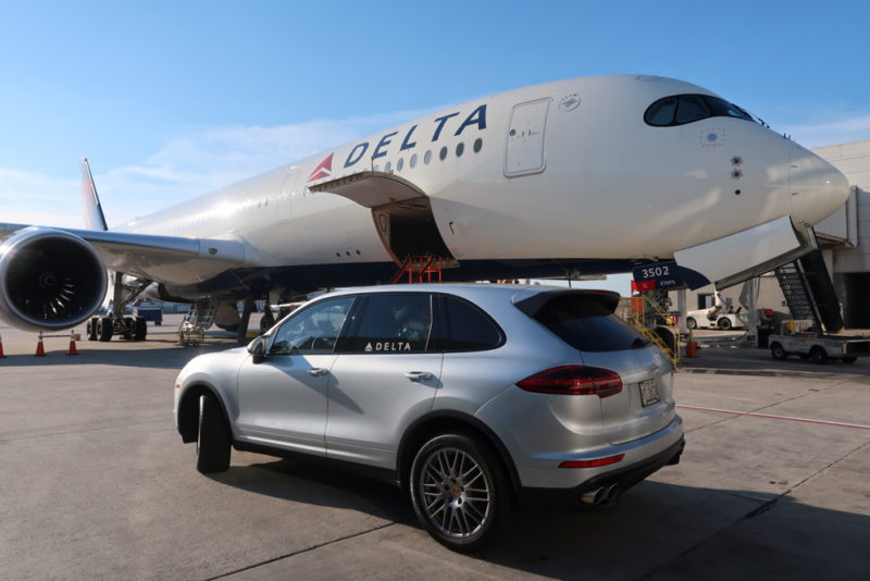 a car parked next to a large airplane