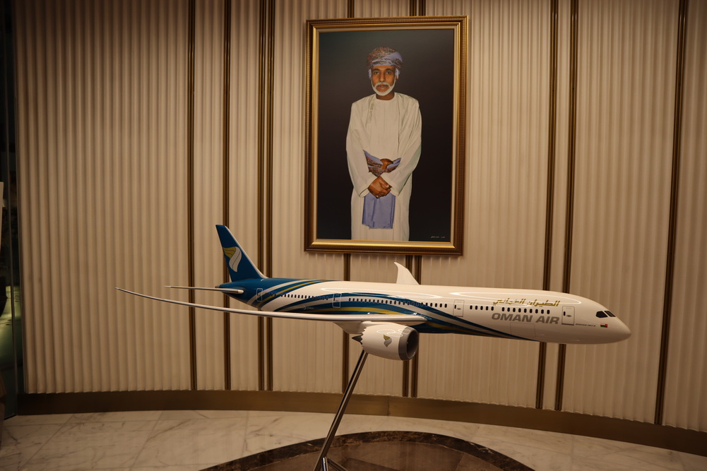 a model airplane on a stand in front of a picture of a man