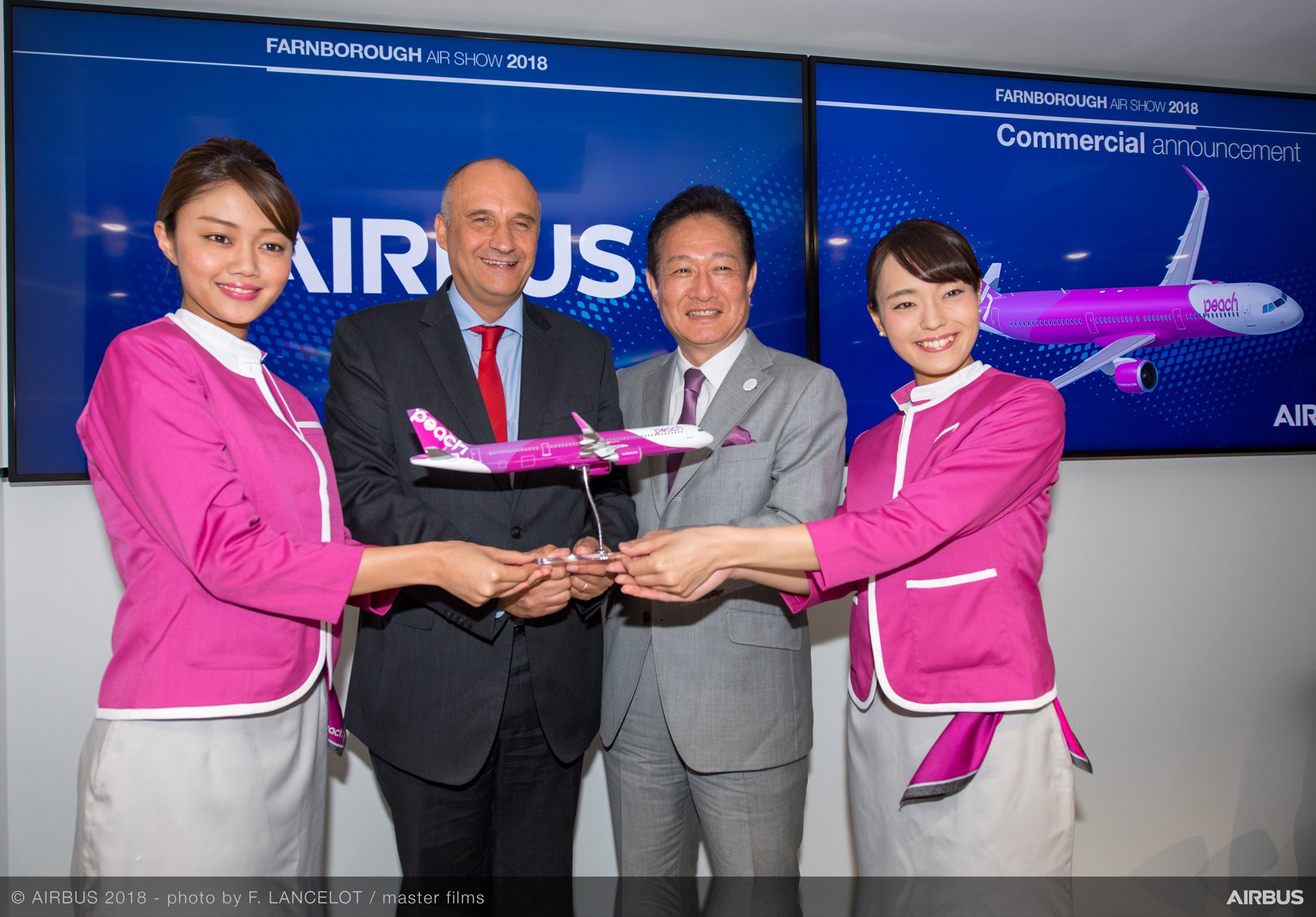 a group of people holding a model airplane