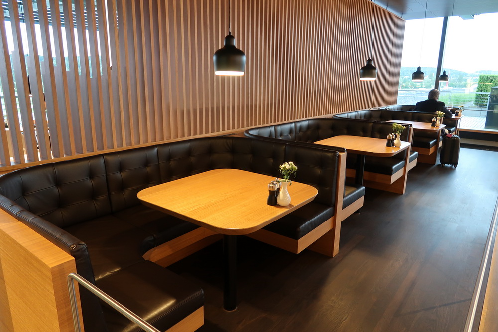 a booth seating with a wooden table and black leather seats