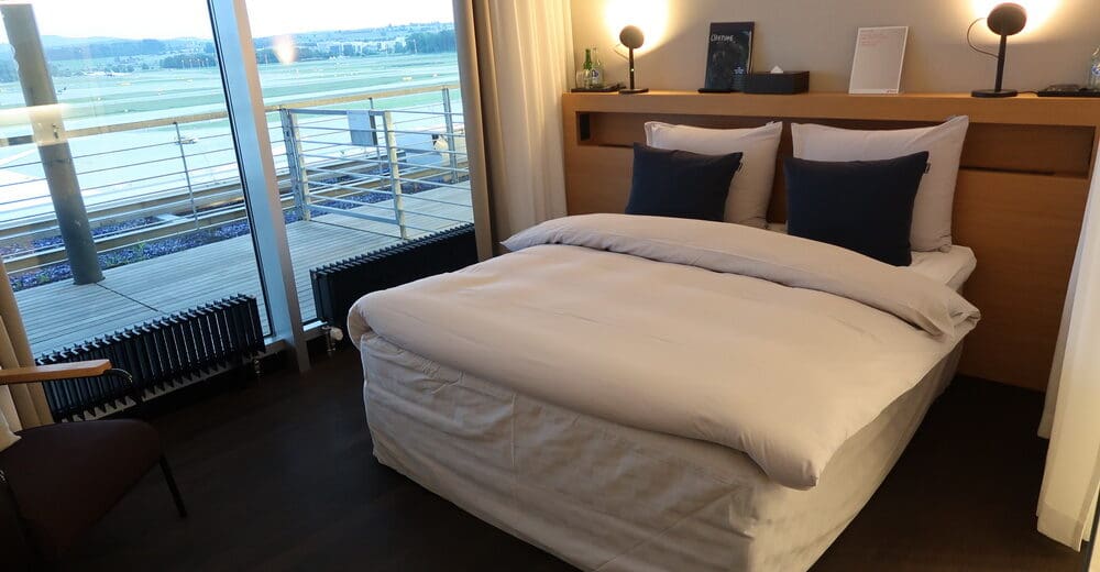 a bed with a wood headboard and a lamp