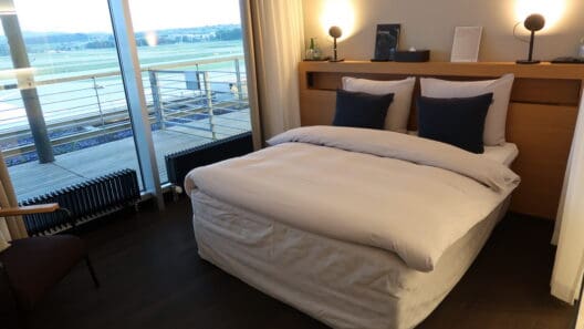 a bed with a wood headboard and a lamp