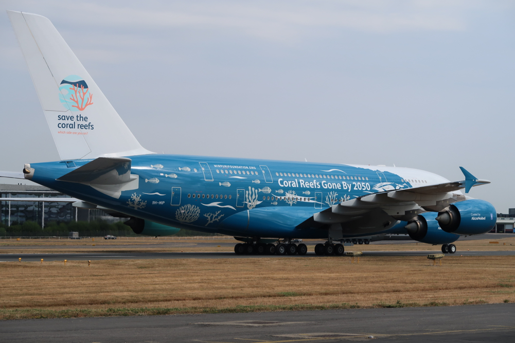 a blue and white airplane on a runway