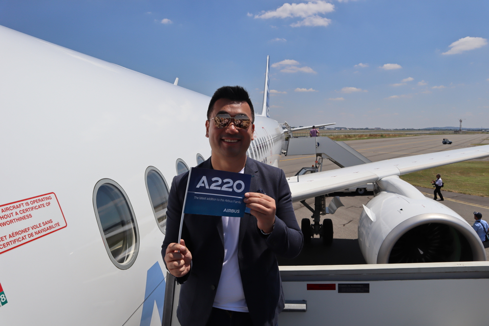 a man holding a sign in front of an airplane