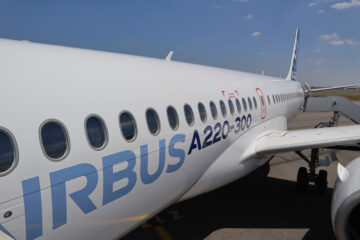 a white airplane with blue writing on it