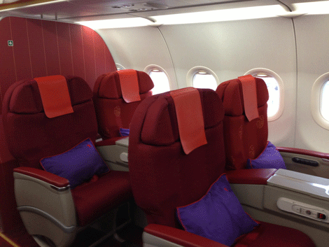 a row of red and purple seats in an airplane