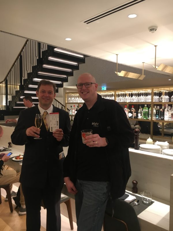 two men holding drinks in a restaurant