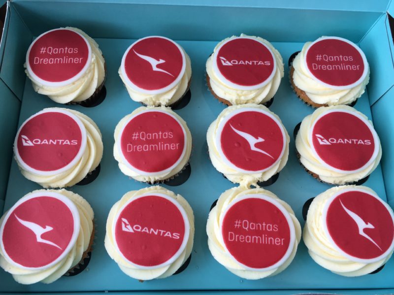 a box of cupcakes with red and white frosting