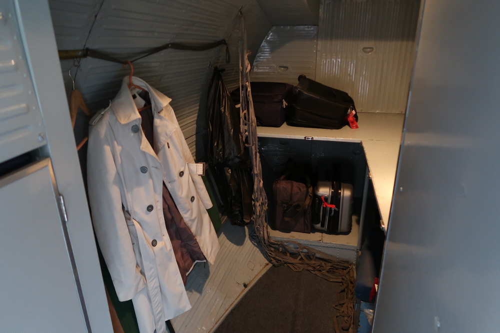 a room with luggage and coats on a swinger