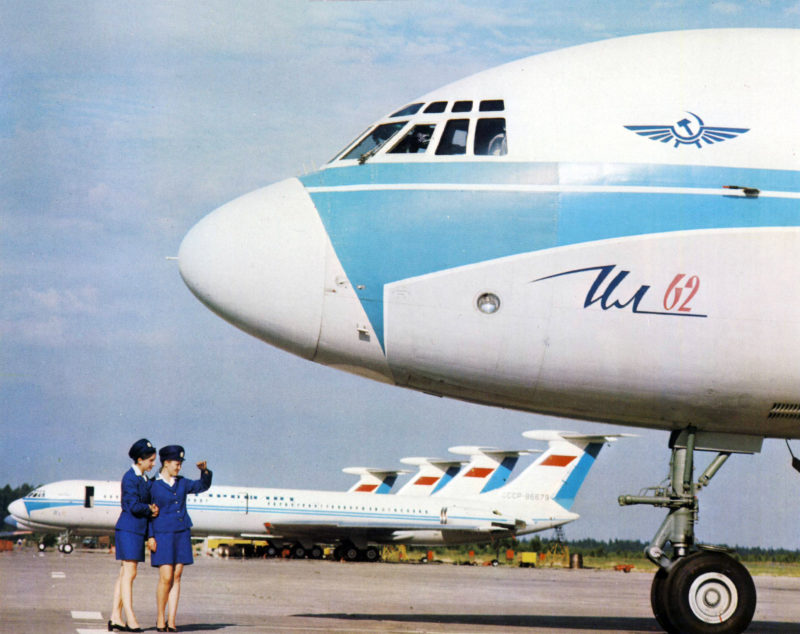 a group of women standing next to a plane
